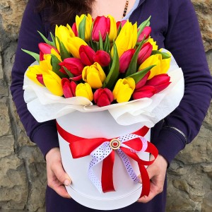 Капелюшна коробка з 45 червоних та жовтих тюльпанів.